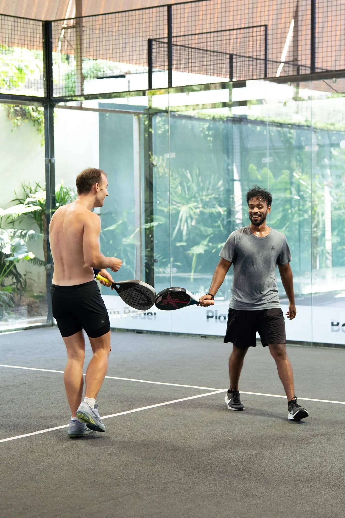 Two players tapping rackets and smiling after a point