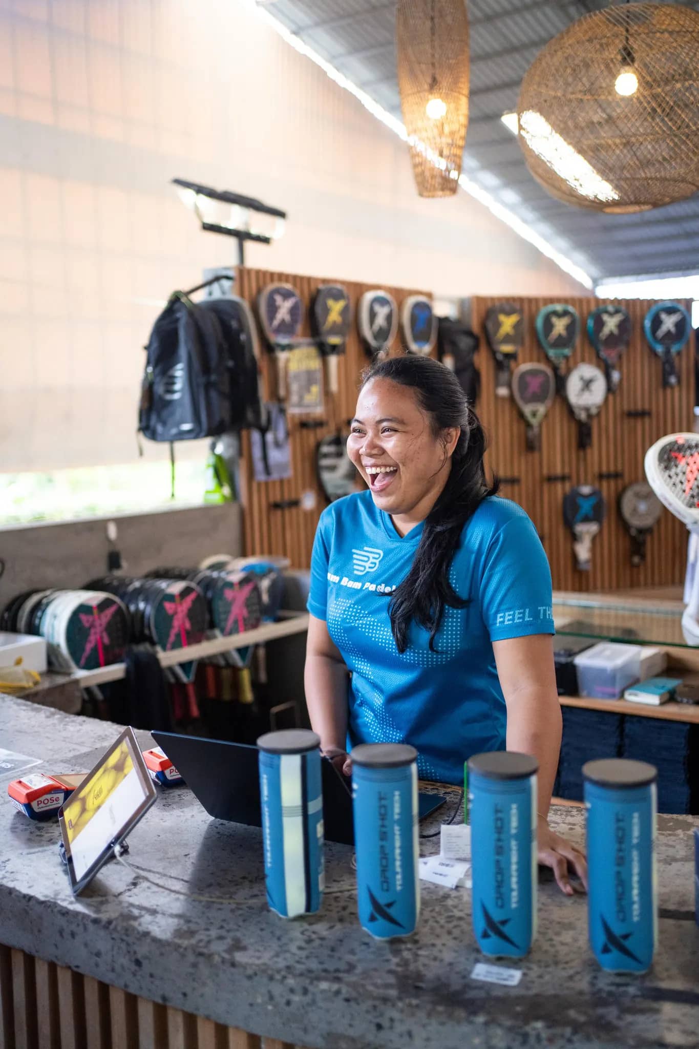 A front-desk team member laughing at the pro-shop counter