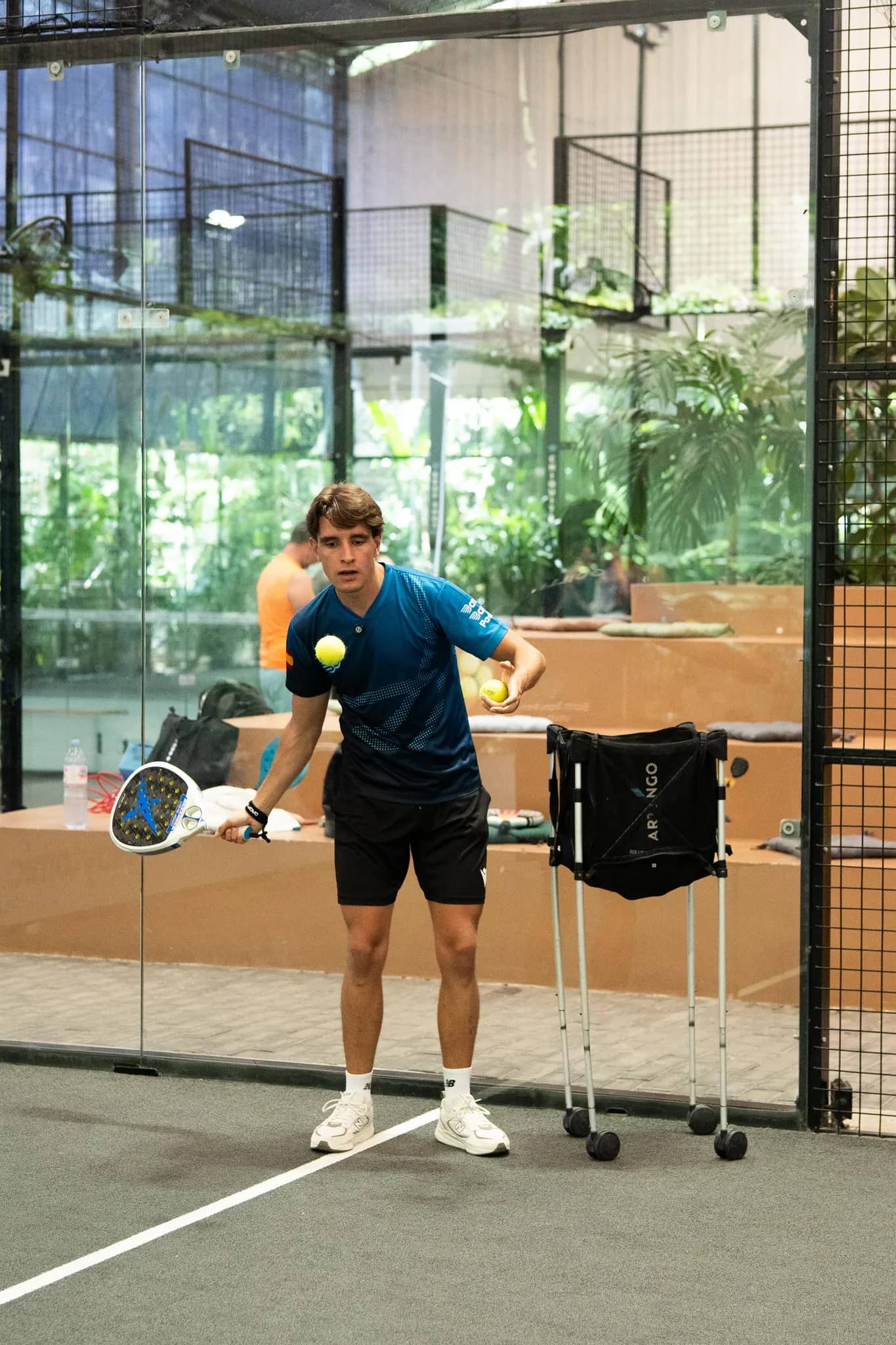 Coach Guille juggling two balls before an adult padel lesson at Bam Bam Padel