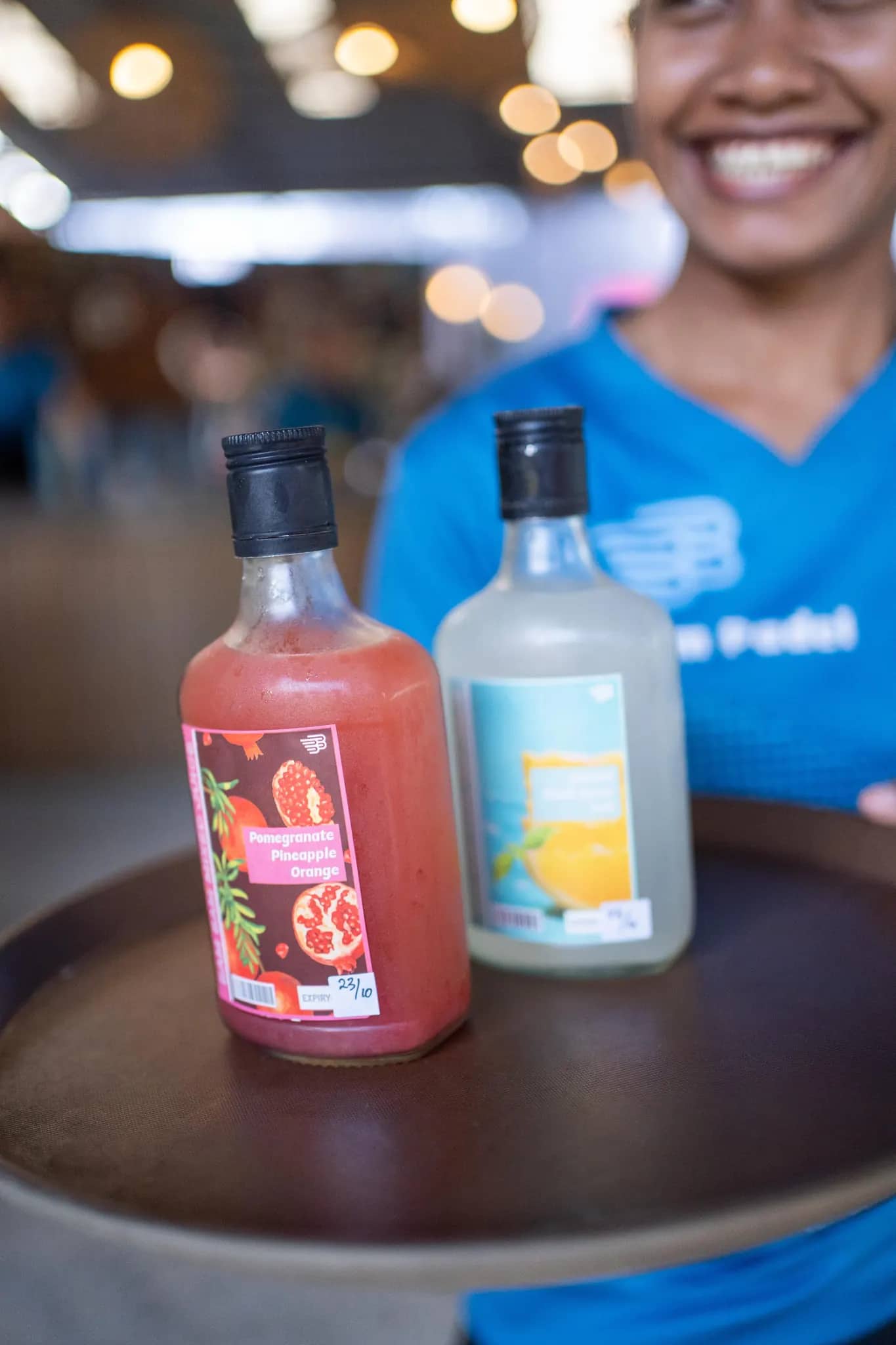 Bottles of house-made pomegranate and pineapple juice on a serving tray