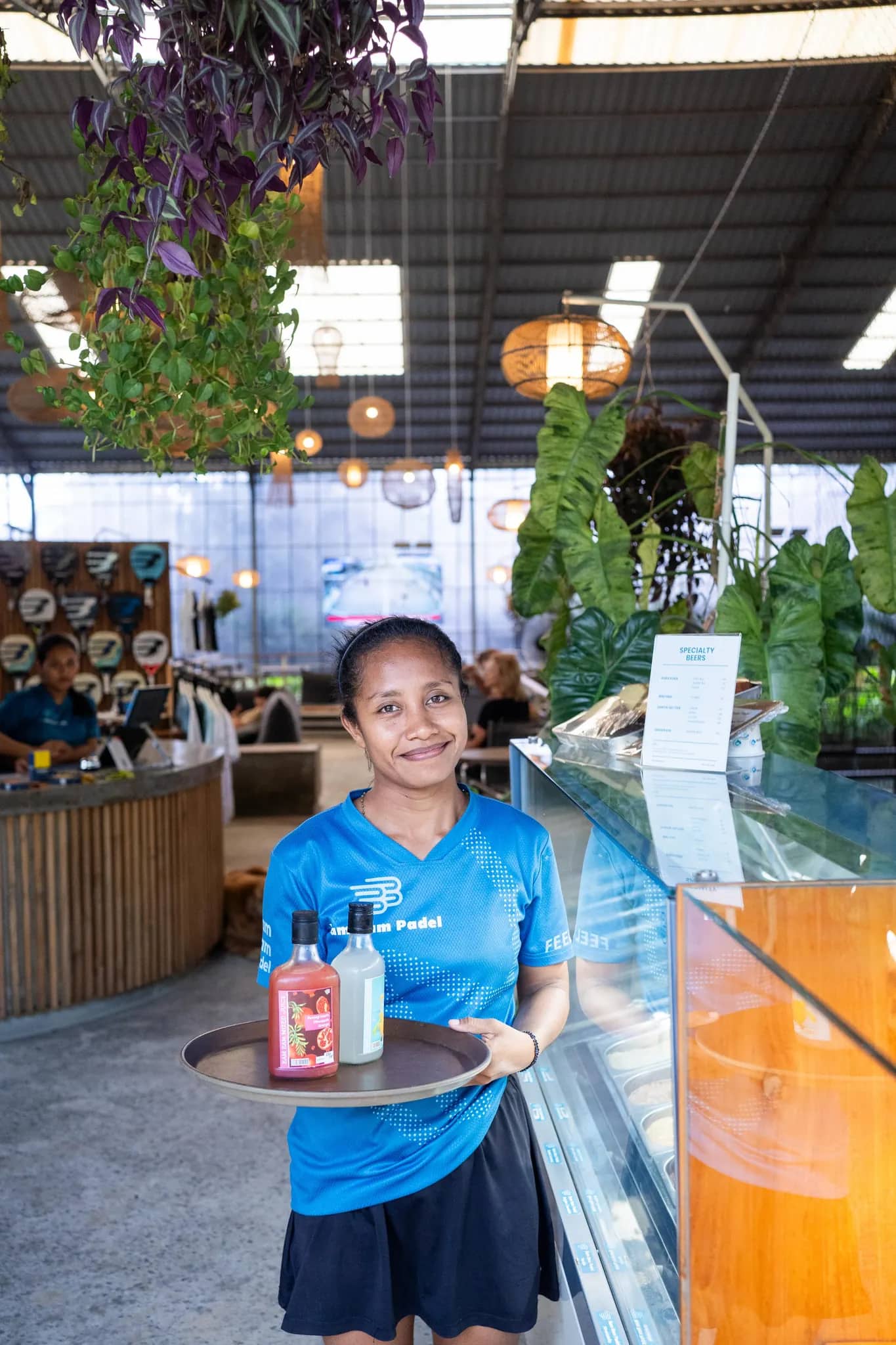 A canteen team member carrying a tray of house-made juices