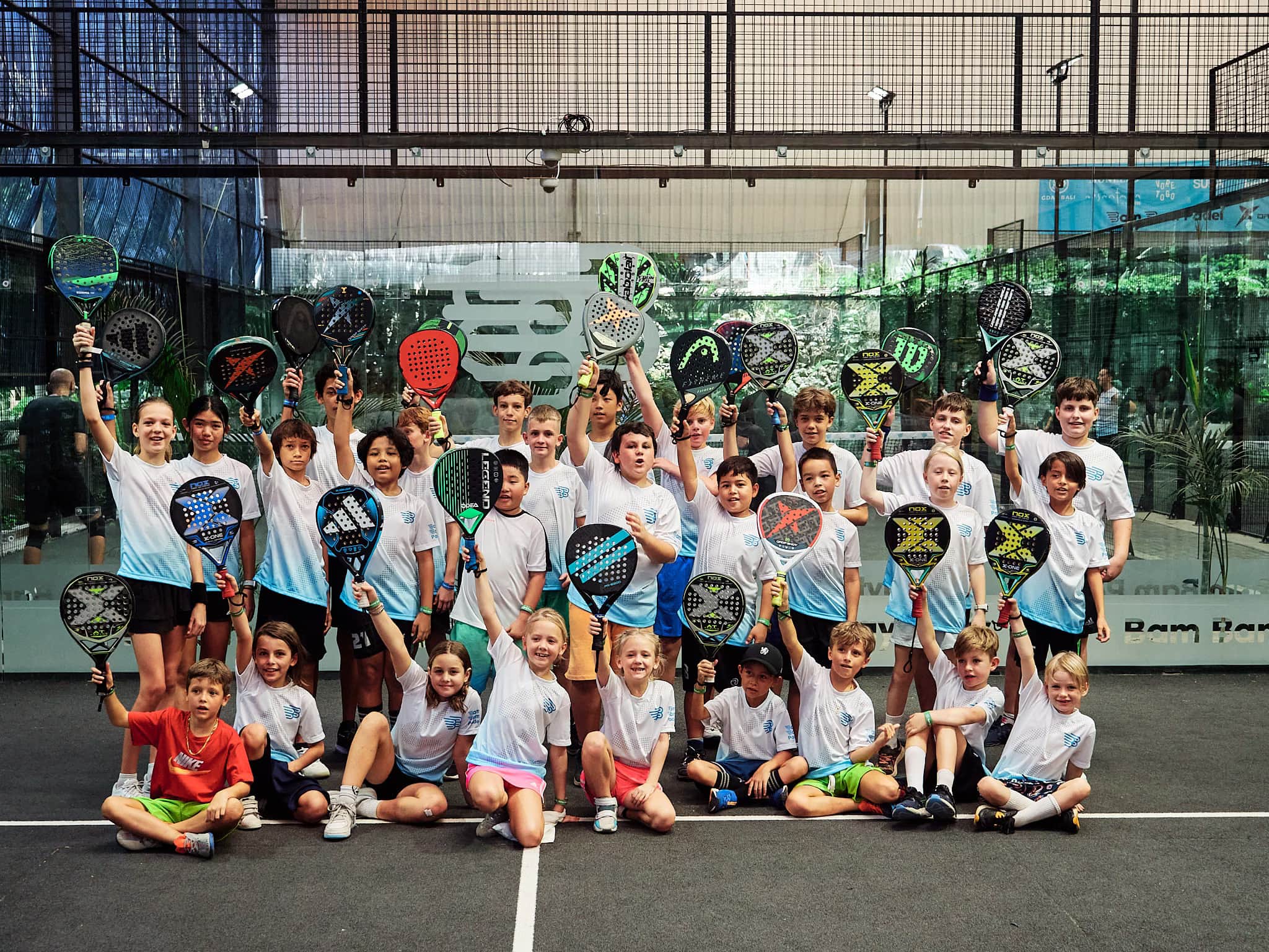 Children from the kids academy on court with their rackets