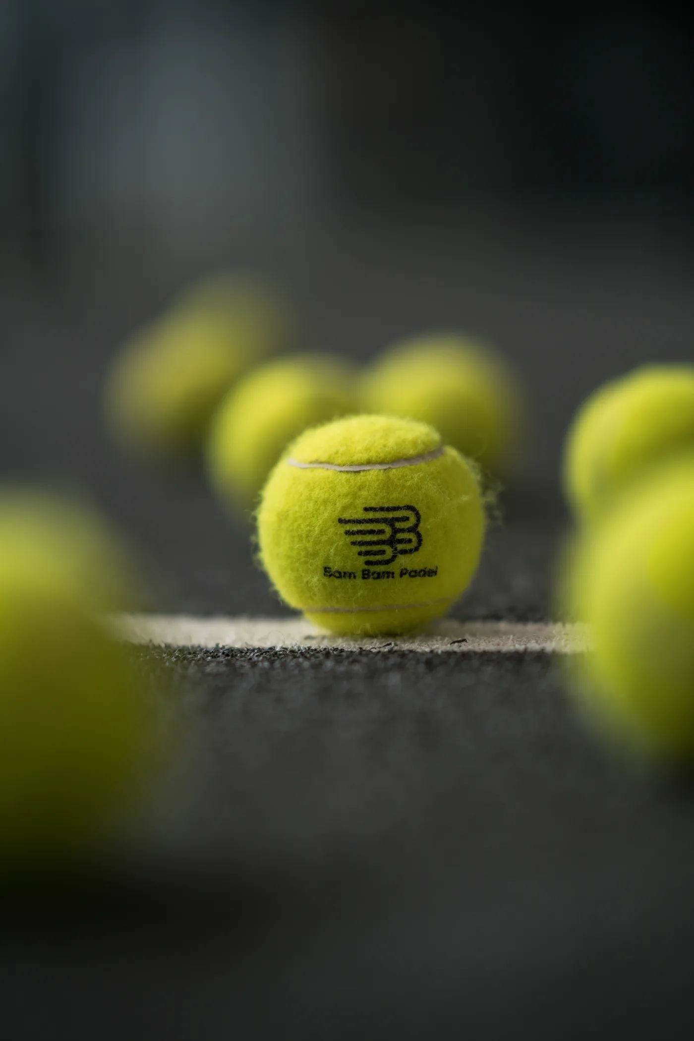 Satu bola Bam Bam Padel dalam fokus tajam di garis servis