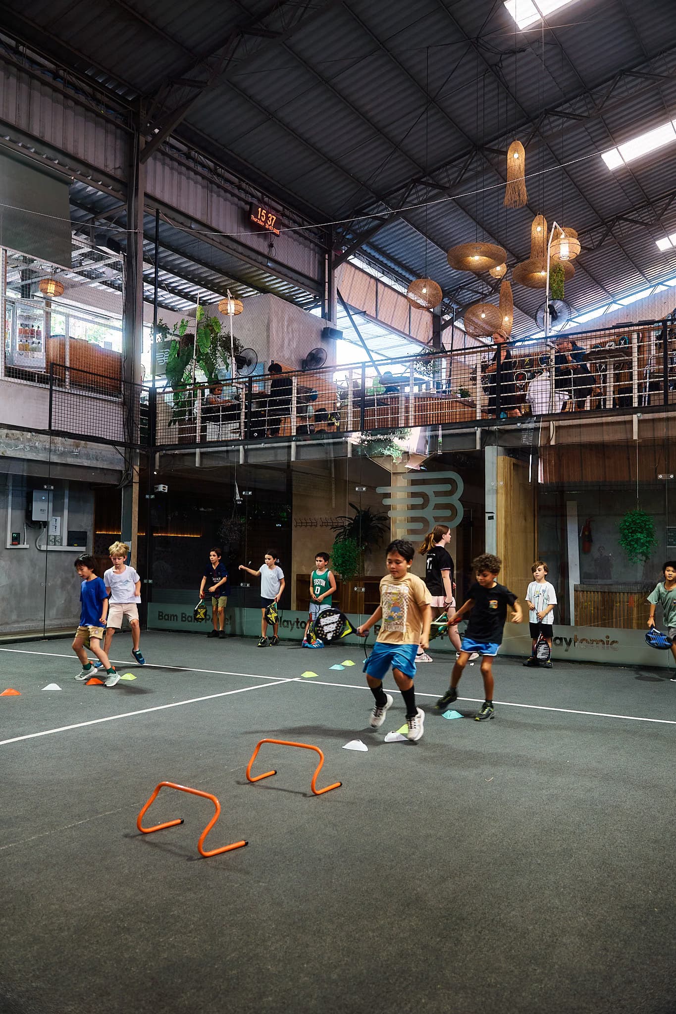 Kids academy training with agility hurdles on court