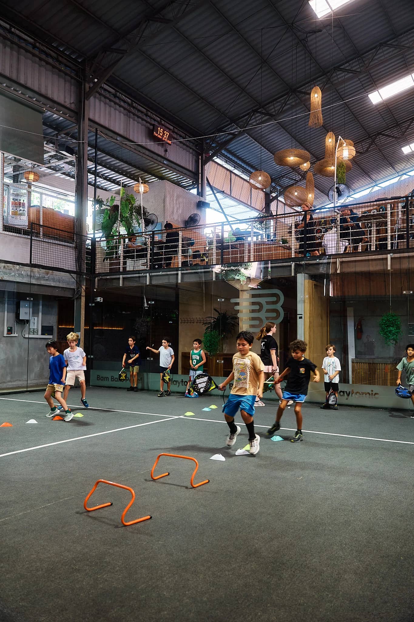Kids academy training with agility hurdles on court